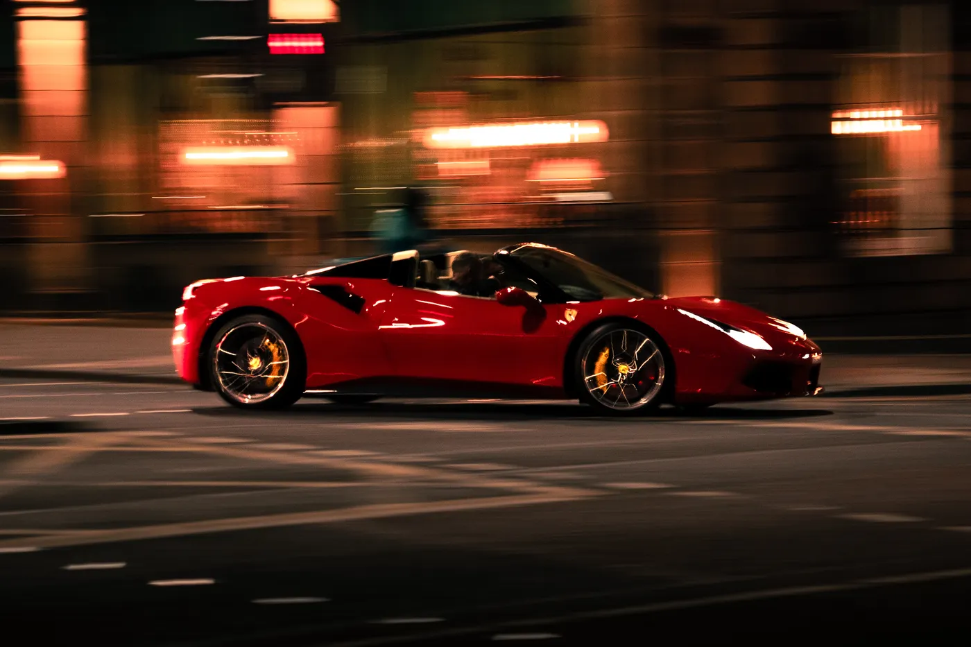 Roter Sportwagen im Mitzieher bei Nacht
